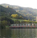 Lávka před obcí Unzmarkt, nad ní hrad 08/2024