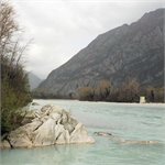 Vápencové skalky a v pozadí vpravo vodočet na řece Tagliamento nad městem Venzone