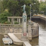 Socha Vltavy u špice Dětského ostrova v Praze s věncem za utonulé
